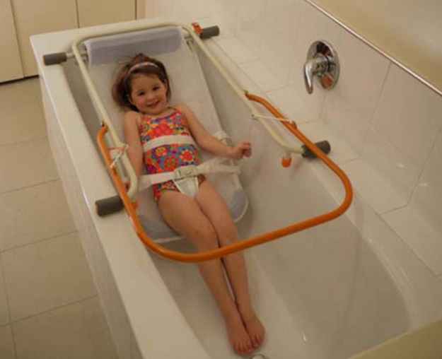 ребёнок  в  ванне на  приспособлении